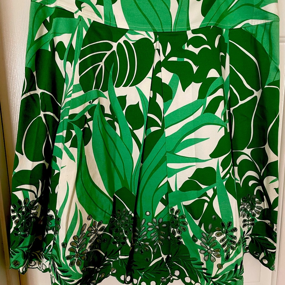 Pleated floral print skirt with side zip, cutout design on hem, and fully lined.